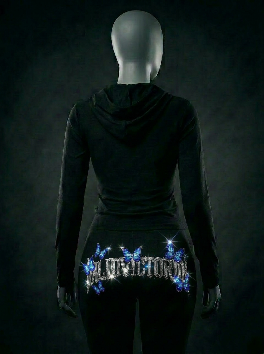 Mannequin wearing black women's zip-up tracksuit with deep sea blue rhinestone butterfly design — back view